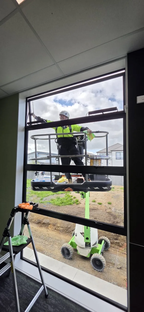 Worker cleaning an exterior window using elevated access
