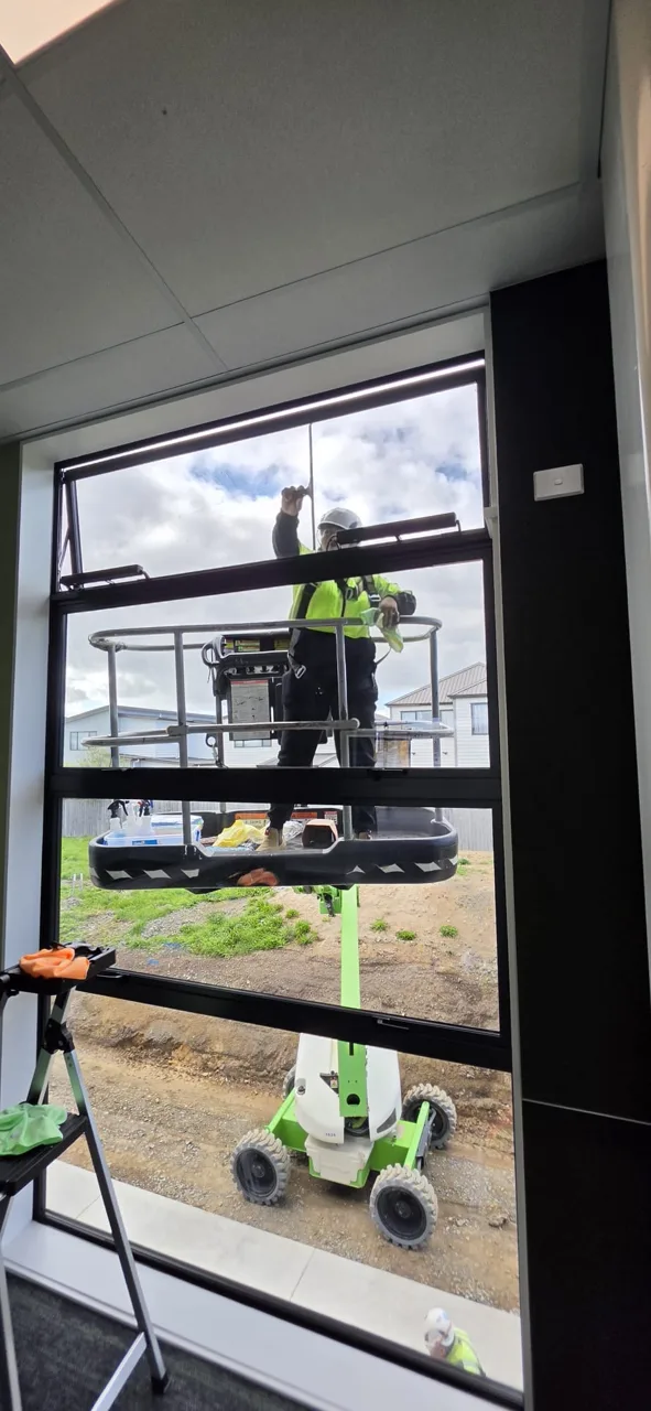 Worker finishing a window clean from an elevated platform