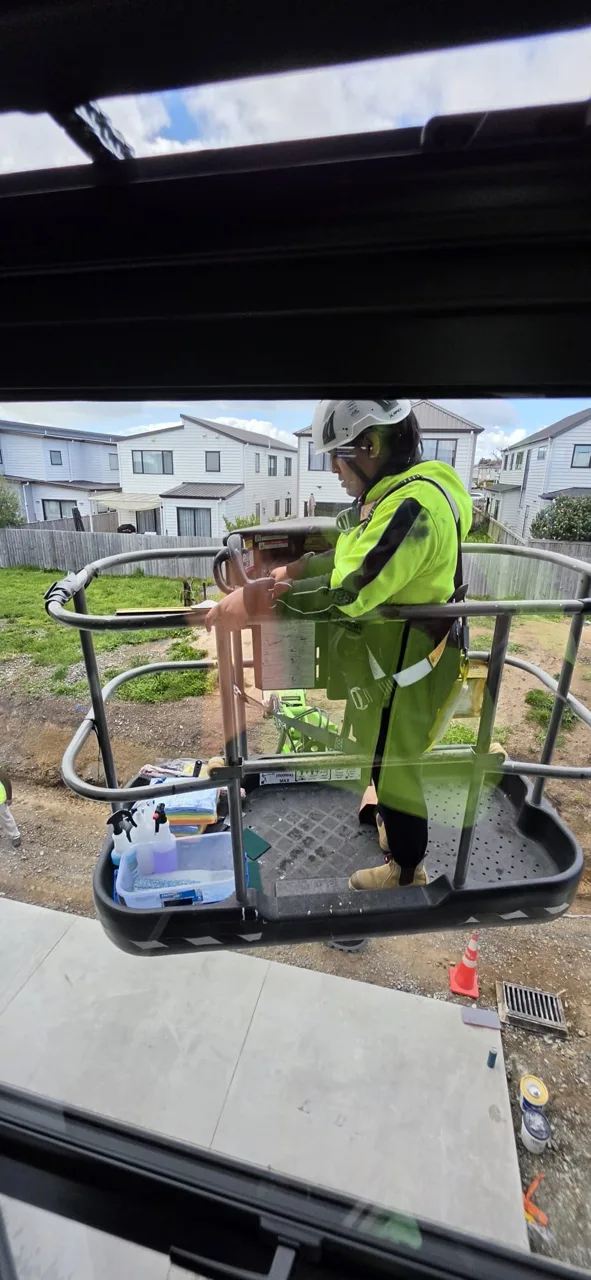 Worker in high-visibility clothing using an elevated work platform